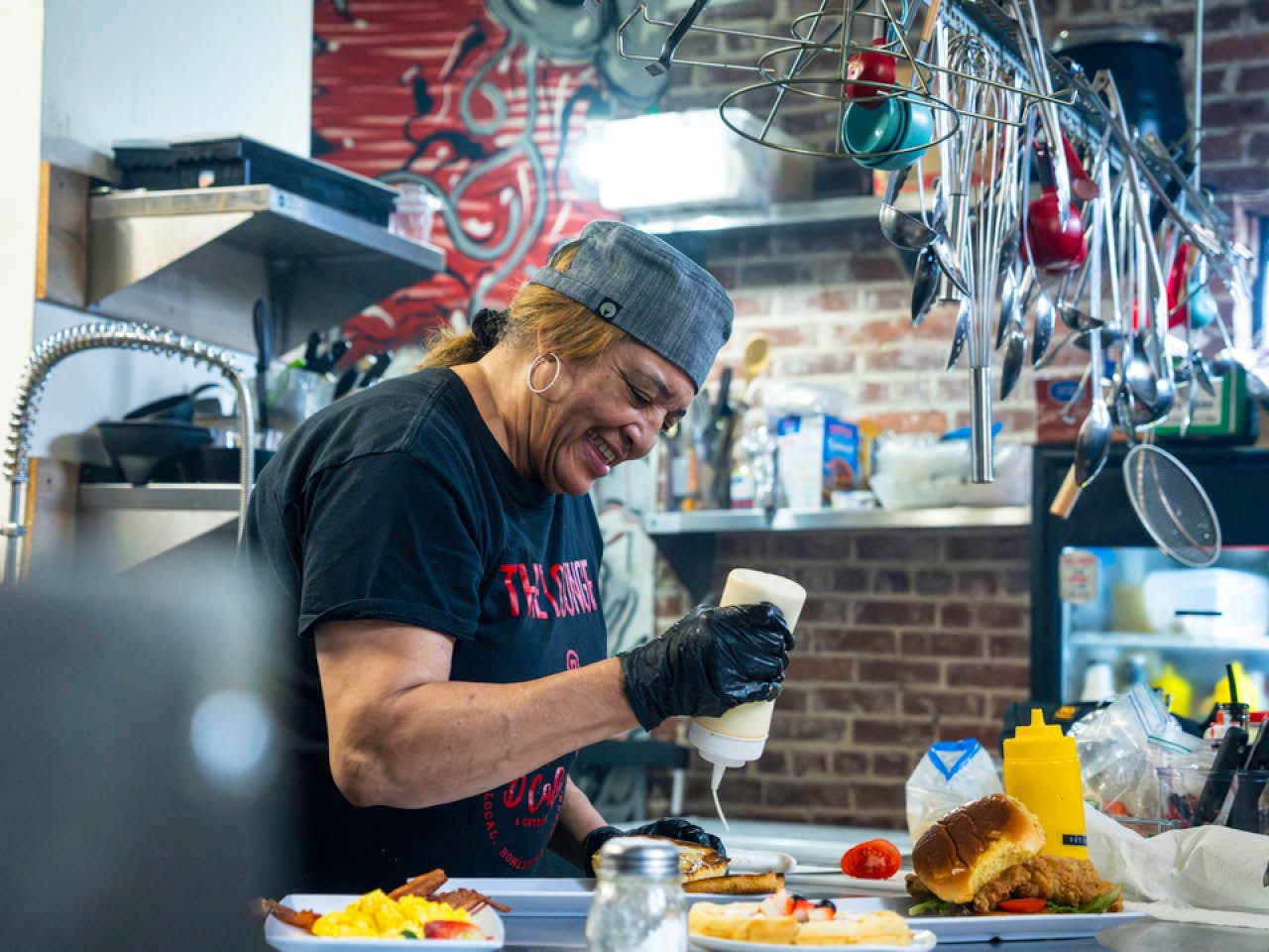 Devotis Lee, owner of D Cafe, preps food in the kitchen of her restaurant in the Westview neighborhood. Photo Credit: Dr. Arshley Emile.