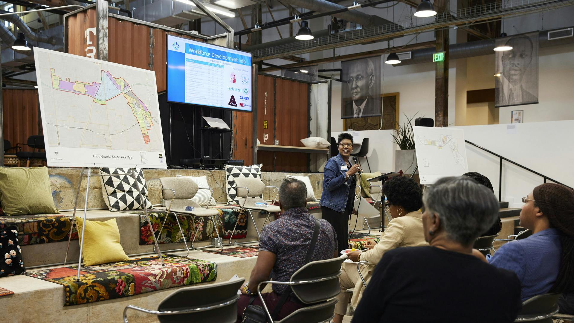 A person addresses a crowd during a community meeting.